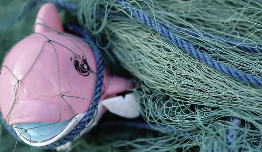 plastic dolfijn in een visnet