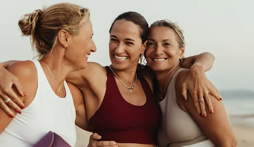 trois femmes en bonne santé, souriantes, vêtues de tenues de yoga