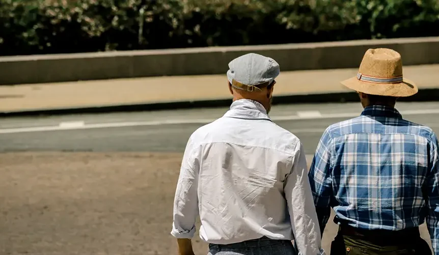 Two senior men walking outdoors in the sunlight, reflecting healthy aging and natural Vitamin D exposure.